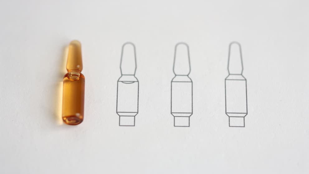 Four abstract pharmaceutical cartridge outlines arranged in a horizontal row on off-white paper, one highlighted in warm amber, clinical minimalism